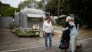 Mary Herring (C), 78, hugs a neighbor as Gayle Cooper (L), 66, looks on in Village Trailer Park in Santa Monica, California July 12, 2012. Developer Marc Luzzatto wants to relocate residents from the trailer park to make way for nearly 500 residences, office space, stores, cafes and yoga studios, close to where a light rail line is being built to connect downtown Los Angeles to the ocean. Village Trailer Park was built in 1951, and 90 percent of its residents are elderly, disabled or both, according to the Legal Aid Society. Many have lived there for decades in old trailers which they bought. The property is valued at as much as $30 million, according the LA Times. Picture taken July 12, 2012. REUTERS/Lucy Nicholson (UNITED STATES - Tags: POLITICS REAL ESTATE BUSINESS SOCIETY TPX IMAGES OF THE DAY) Published: Čec. 14, 2012, 6:54 dop.