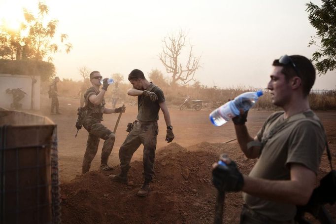 French soldiers drink water as they prepare a security zone at Bamako airport January 23, 2013. The zone was established in the evening of January 22. A split emerged on Thursday in the alliance of Islamist militant groups occupying northern Mali as French and African troops prepared a major ground offensive aimed at driving al Qaeda and its allies from their safe haven in the Sahara. Picture taken January 23, 2013. REUTERS/Malin Palm (MALI - Tags: POLITICS CIVIL UNREST CONFLICT MILITARY) Published: Led. 24, 2013, 7:10 odp.