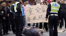 A survivor falls to the ground during a protest by villagers against the lack of rescue operations after Saturday's earthquake, at Chaoyang village in Lu Shan county of Ya'an, Sichuan province April 22, 2013. Rescuers struggled to reach a remote, rural corner of southwestern China on Sunday as the toll of the dead and missing from the country's worst earthquake in three years climbed to 208 with almost 1,000 serious injuries. The 6.6 magnitude quake struck in Lushan county, near the city of Ya'an in the southwestern province of Sichuan, close to where a devastating 7.9 quake hit in May 2008, killing 70,000. The Chinese characters on the sign read, "No one cares for the serious disaster, demanding the government to inspect on site". REUTERS/Jason Lee (CHINA - Tags: DISASTER ENVIRONMENT CIVIL UNREST) Published: Dub. 22, 2013, 8:38 dop.