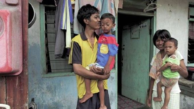 Paiman je dělník v indonéské továrně Panarub, která vyrábí kopačky Adidas. "Můj příjem nestačí na to, aby pokryl základní životní potřeby pro mou rodinu, tak jsem si musel vzít půjčku," vysvětluje, když stojí se svou ženou a dvěma dětmi před svým příbytkem.