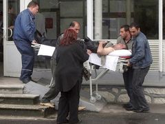Záchranáři odvážejí příbuzného jedné z obětí leteckého neštěstí u letoviska Soči, který zkolaboval při čekání na informace o příbuzných, kteří letěli v havarovaném arménském letadle.
