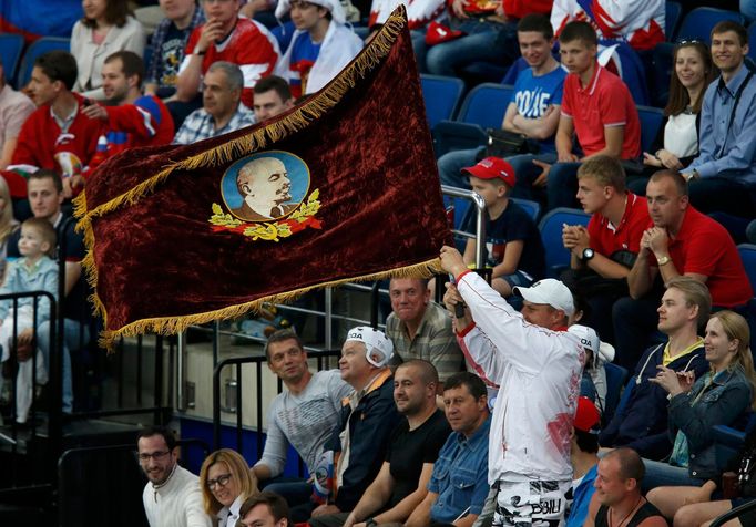 A supporter waves a flag with Vladimir Ilici Lenin's portrait during the men's ice hockey World Championship quarter-final game between Russia and France at Minsk Arena i