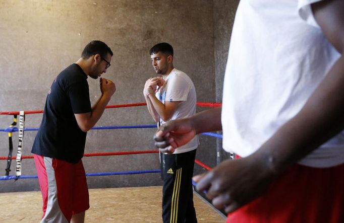 Unemployed Belgian Mohamed Sammar (C) listens to the instructions of coach Abdel El Ouadi (L) during a "Fit for a job" boxing class in Brussels June 14, 2013. Sammar, 27, has been looking for a job in the construction sector for 2 years. "Fit for a job" is the initiative of former Belgian boxing champion Bea Diallo, whose goal was to restore the confidence of unemployed people and help them find a job through their participation in sports. Picture taken June 14, 2013. REUTERS/Francois Lenoir (BELGIUM - Tags: SPORT BOXING SOCIETY BUSINESS EMPLOYMENT) Published: Čec. 5, 2013, 4:43 odp.