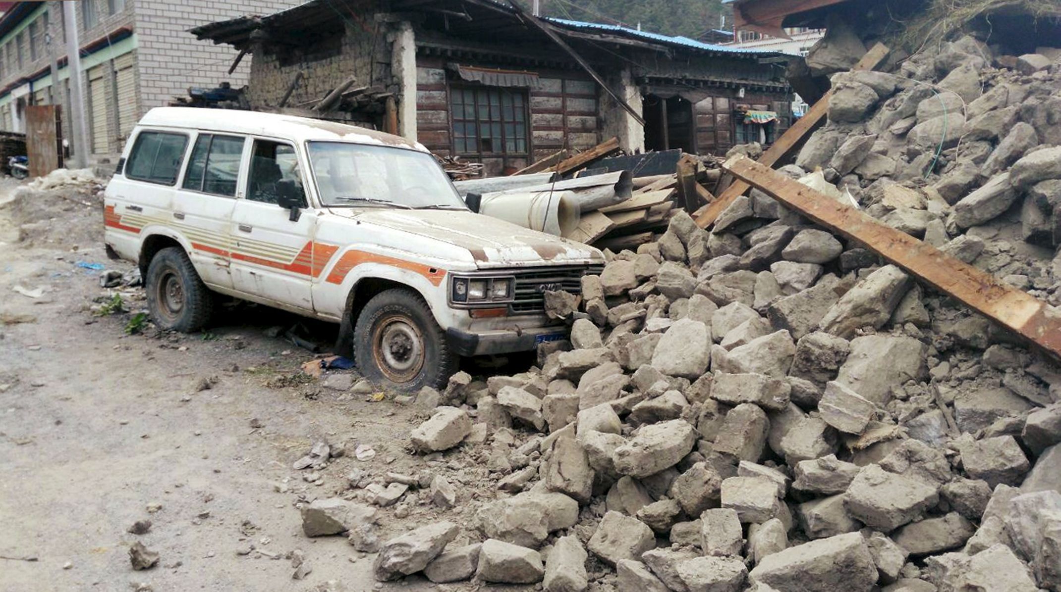 Car is seen next to a collapsed house, after a 7.9 magnitude earthquake hit Nepal, in Xigaze Prefecture