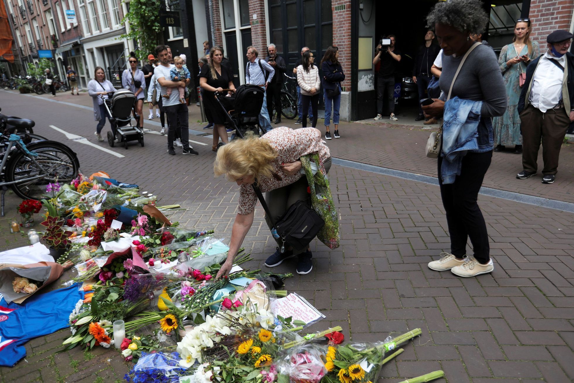Lidé nosí květiny na místo, kde střelec zasáhl pěti kulkami Petera de Vriese.