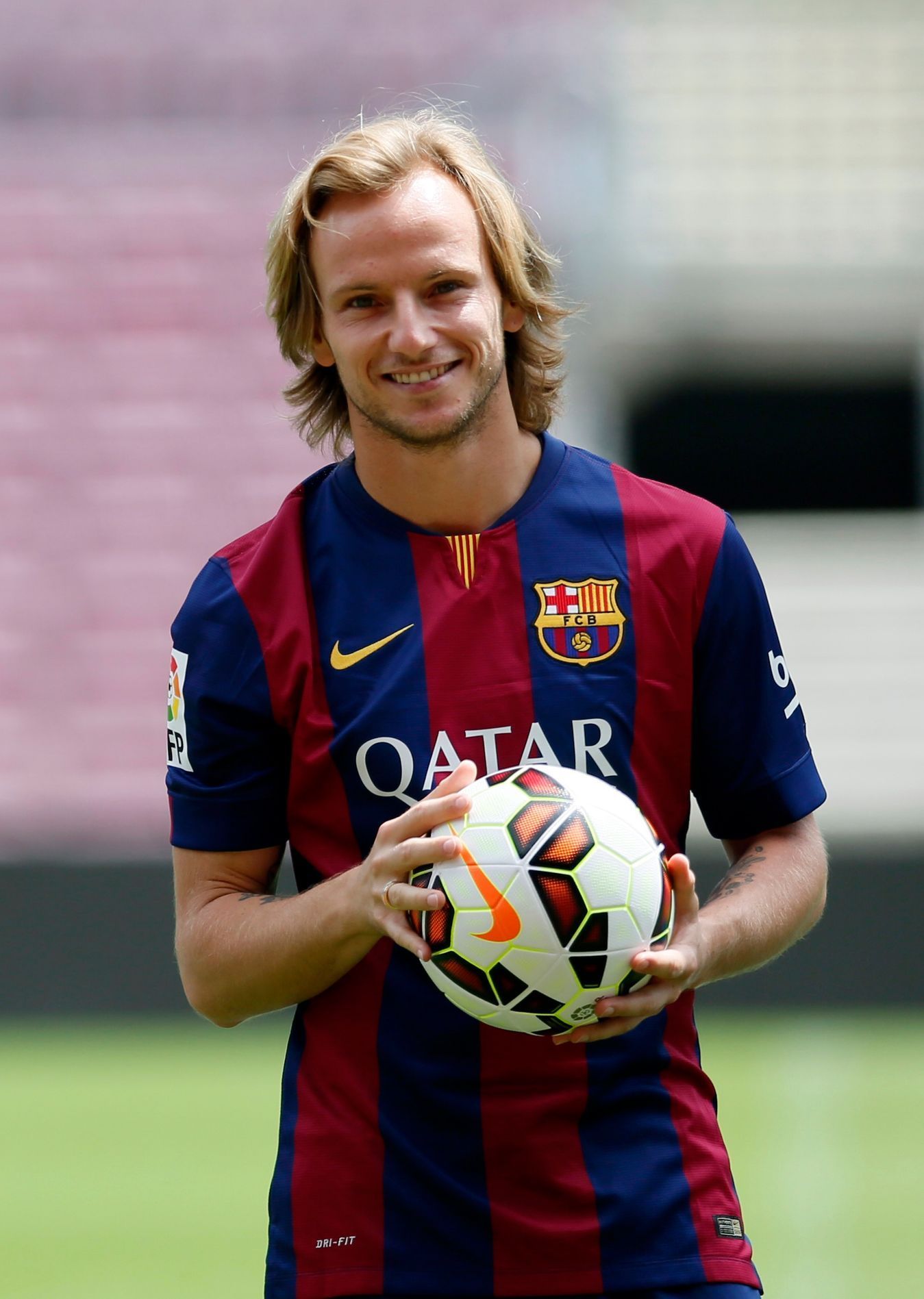 FC Barcelona's newly signed soccer player Ivan Rakitic from Croatia poses for pictures in his new jersey during his presentation at Camp Nou stadium, in Barcelona