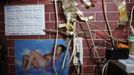 A picture of a naked woman is seen next to electrical wires in the home of Xiao Cao, a 57-year-old gay man, in Shanghai April 22, 2012. China's gay community has long been on the edges of society but it is gradually becoming more accepted. Cao, who is an unemployed drag queen, is one whose life lifts the curtain on a less romanticised view of Chinese homosexuals. Living in an eight square metre apartment behind a public toilet and with a monthly income of 500 yuan ($79) from social insurance, he passes his days dancing in public and spending time with friends at gay clubs. Picture taken April 22, 2012. REUTERS/Aly Song (CHINA - Tags: SOCIETY) TEMPLATE OUT. CHINA OUT. NO COMMERCIAL OR EDITORIAL SALES IN CHINA. ATTENTION EDITORS PICTURE 05 OF 28 OF PACKAGE 'GAY AND OUT IN CHINA' TO FIND ALL IMAGES SEARCH 'GAY OUT CHINA' Published: Čer. 1, 2012, 12:35 dop.