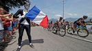 The pack of riders cycles past a French flag on Bastille day during the 242.5 km fifteenth stage of the centenary Tour de France cycling race from Givors to Mont Ventoux