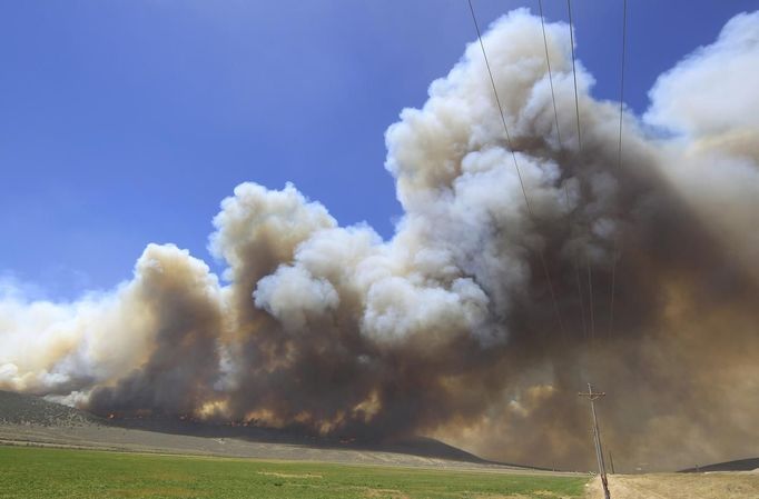 Smoke from the Wood Hollow Fire fills the sky north of Fairview, Utah, June 26, 2012. More than 500 structures have been threatened by the Wood Hollow fire, forcing up to 1,500 people from homes. REUTERS/George Frey (UNITED STATES - Tags: ENVIRONMENT DISASTER) Published: Čer. 26, 2012, 10:23 odp.