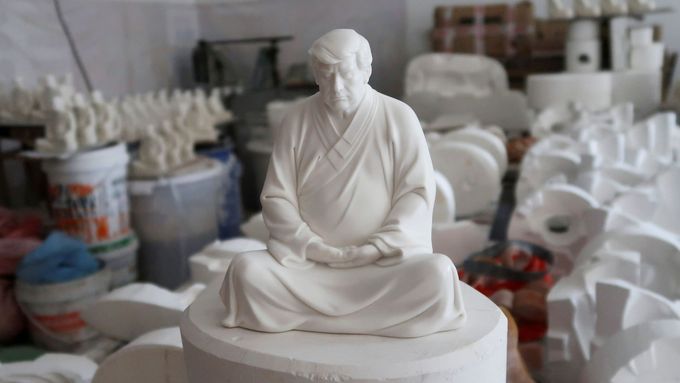 Čínský nábytkář Hong Jinshi vyrábí sošky Donalda Trumpa v buddhistické póze.