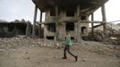 A boy walks past a building damaged by a recent Saudi-led air strike in Yemen's capital Sanaa July 13, 2015