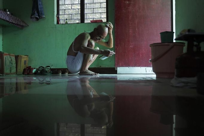 Mahesh Chaturvedi, 63, who dresses up like Mahatma Gandhi, shaves his head at his residence in the outskirts of New Delhi October 1, 2012. Chaturvedi says that the soul of Gandhi resides in him and he has been sent to continue the work of Father of the Nation. After his self proclaimed transformation in 2002 as Gandhi, Chaturvedi has been travelling extensively and plays up to his startling resemblance to Gandhi at protests and demonstrations. Picture taken October 1, 2012. REUTERS/Mansi Thapliyal (INDIA - Tags: SOCIETY) Published: Lis. 26, 2012, 3:52 dop.