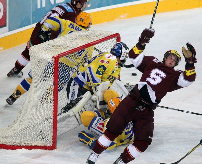 Hokejista Sparty Praha Lukáš Luňák padá za sedícím Daliborem Řezníčkem a před brankářem Lubošem Horčičkou v utkání 8. kola Tipsport extraligy 2012/13 se Zlínem.