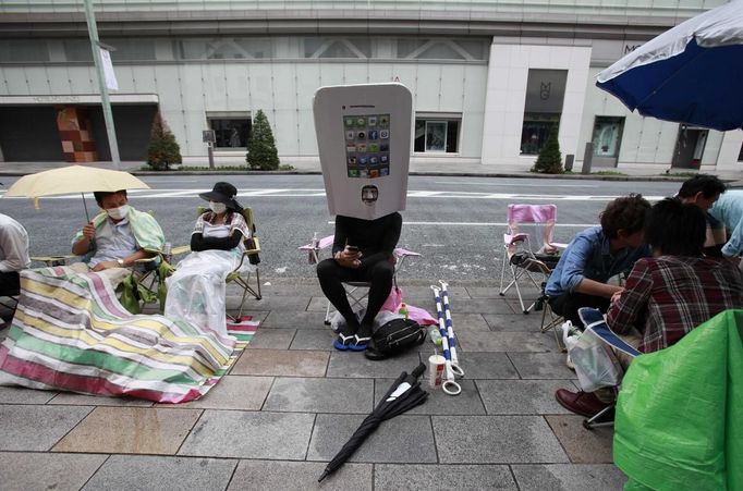 An Apple fan, who is dressed up as an iPhone, queues since last night to buy Apple Inc's iPhone 5 outside an Apple Store in Tokyo's Ginza district September 21, 2012. A crowd of over seven hundred people gathered outside the store from early morning on the first day of sales in Japan for Apple's iPhone 5. REUTERS/Yuriko Nakao (JAPAN - Tags: BUSINESS SCIENCE TECHNOLOGY) Published: Zář. 20, 2012, 11:08 odp.