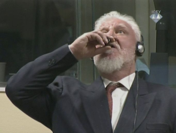 Slobodan Praljak ve chvíli, kdy vypil neznámou tekutinu. Tvrdil, že jde o jed.