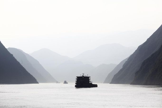 Ships sail on the Yangtze River near Badong, 100km (62 miles) from the Three Gorges dam in Hubei province in this August 7, 2012 file photo. China relocated 1.3 million people during the 17 years it took to complete the Three Gorges dam. Even after finishing the $59 billion project last month, the threat of landslides along the dam's banks will force tens of thousands to move again. It's a reminder of the social and environmental challenges that have dogged the world's largest hydroelectric project. While there has been little protest among residents who will be relocated a second time, the environmental fallout over other big investments in China has become a hot-button issue ahead of a leadership transition this year. Picture taken on August 7, 2012. To match story CHINA-THREEGORGES/ REUTERS/Carlos Barria/Files (CHINAPOLITICS MARITIME - Tags: POLITICS ENVIRONMENT BUSINESS ENERGY MARITIME TPX IMAGES OF THE DAY) Published: Srp. 22, 2012, 8:52 odp.