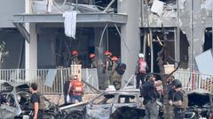 Emergency services officials inspect damage to buildings hit following a missile strike from Iran, in Be'er Sheva