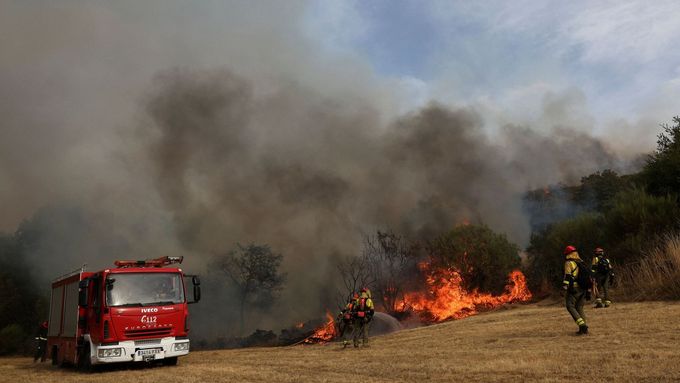 Hasiči zasahují při požáru lesa ve vesnici Parafita v regionu Galicie ve Španělsku, 12. srpna 2025.