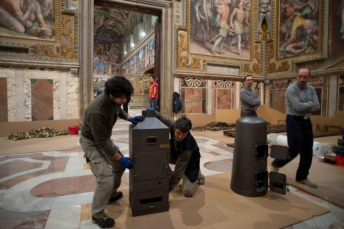 Workers prepare the stoves that will be used to burn the ballots during the next conclave in the Sistine Chapel at the Vatican in this photo released by Osservatore Romano March 7, 2013. REUTERS/Osservatore Romano. (VATICAN - Tags: RELIGION) ATTENTION EDITORS - THIS IMAGE WAS PROVIDED BY A THIRD PARTY. FOR EDITORIAL USE ONLY. NOT FOR SALE FOR MARKETING OR ADVERTISING CAMPAIGNS. THIS PICTURE IS DISTRIBUTED EXACTLY AS RECEIVED BY REUTERS, AS A SERVICE TO CLIENTS Published: Bře. 7, 2013, 10:45 dop.