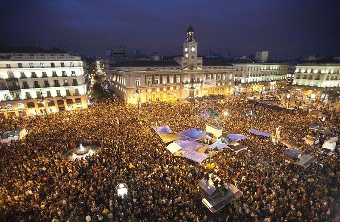 Demonstrace ve Španělsku začaly15. května, jako protesty proti vládě dvou politických stran (lidové a socialistické), politické korupci, špatnému volebnímu systému a narůstajícímu vlivu Evropské unie. Demonstranti požadovali také právo na bydlení, práci, kulturu, péči o zdraví, vzdělání, možnost politické participace, svobodu pro osobní rozvoj a základní životní potřeby. Na snímku dav na náměstí Puerta del Sol v Madridu, 18. května 2011.