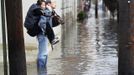 A man carries his wife through the floodwaters in Hoboken, New Jersey, October 31, 2012. The U.S. Northeast began crawling back to normal on Wednesday after monster storm Sandy crippled transportation, knocked out power for millions and killed at least 45 people in nine states with a massive storm surge and rain that caused epic flooding. REUTERS/Gary Hershorn (UNITED STATES - Tags: ENVIRONMENT DISASTER) Published: Říj. 31, 2012, 6:09 odp.