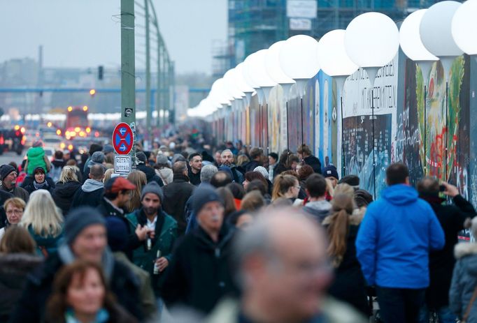 Lidé jdou podél East Side Gallery - torza jedné z nejslavnějších zdí na světě.