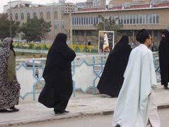 Typický obrázek kómské ulice. Přísně zahalené žena a muslimští klerikové.