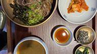 Kombinace rýže, marinovaného hovězího, sezonní zeleniny a hub je doplněna o miso polévku a banchan.