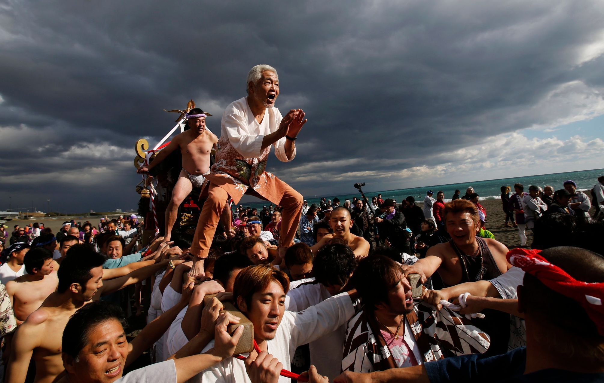 Men ride on a &quot;mikoshi&quot; or portable shrine as local people carry it into the sea during a festival to wish peace in the ocean and good fortune in the new year in Oiso, west of Tokyo