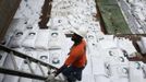 A worker stands nest to gags labeled "Cuban Raw Sugar" are seen inside a North Korean flagged ship "Chong Chon Gang" docked at the Manzanillo Container Terminal in Colon City July 16, 2013. Panama detained the North Korean-flagged ship from Cuba as it headed to the Panama Canal and said it was hiding weapons in brown sugar containers, sparking a standoff in which the ship's captain attempted to commit suicide. Panama's President Ricardo Martinelli said the undeclared weapons were detected inside the containers when Panamanian authorities stopped the ship, suspecting it was carrying drugs. REUTERS/Carlos Jasso (PANAMA - Tags: CRIME LAW DRUGS SOCIETY POLITICS) Published: Čec. 16, 2013, 9:30 odp.