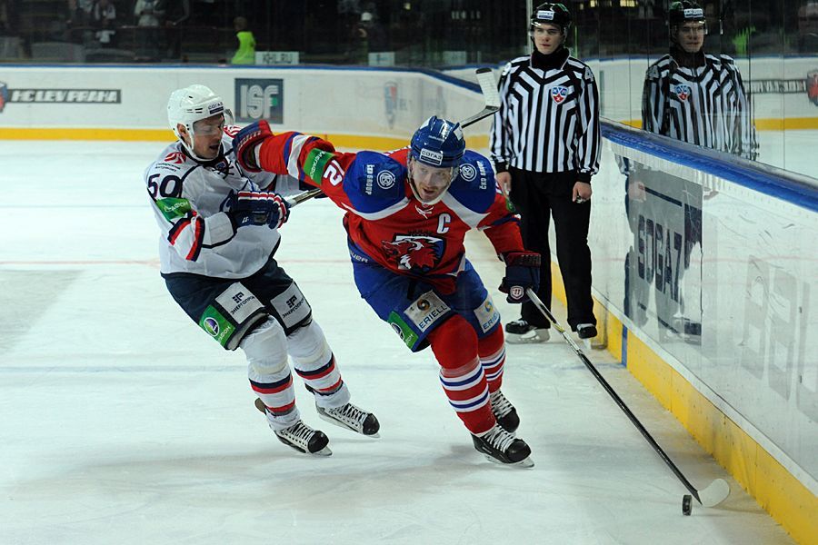 Hokejista Lva Praha Jiří Novotný uniká s pukem před Maximem Krivonožkinem v utkání KHL 2012/13 proti Novosibirsku.