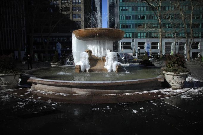 A fountain partially frozen into ice is seen at Bryant Park in New York, January 24, 2013. Frigid arctic air held the U.S. Midwest and Northeast in its icy grip on Wednesday, with the cold so dangerous that municipal emergency warming centers opened up and ski resorts shut down. Wintry conditions from Minneapolis to Washington marked the coldest conditions in many parts of the United States in four years, but were nowhere near the record lows for January, meteorologists said. REUTERS/Eduardo Munoz (UNITED STATES - Tags: ENVIRONMENT SOCIETY) Published: Led. 24, 2013, 7:48 odp.