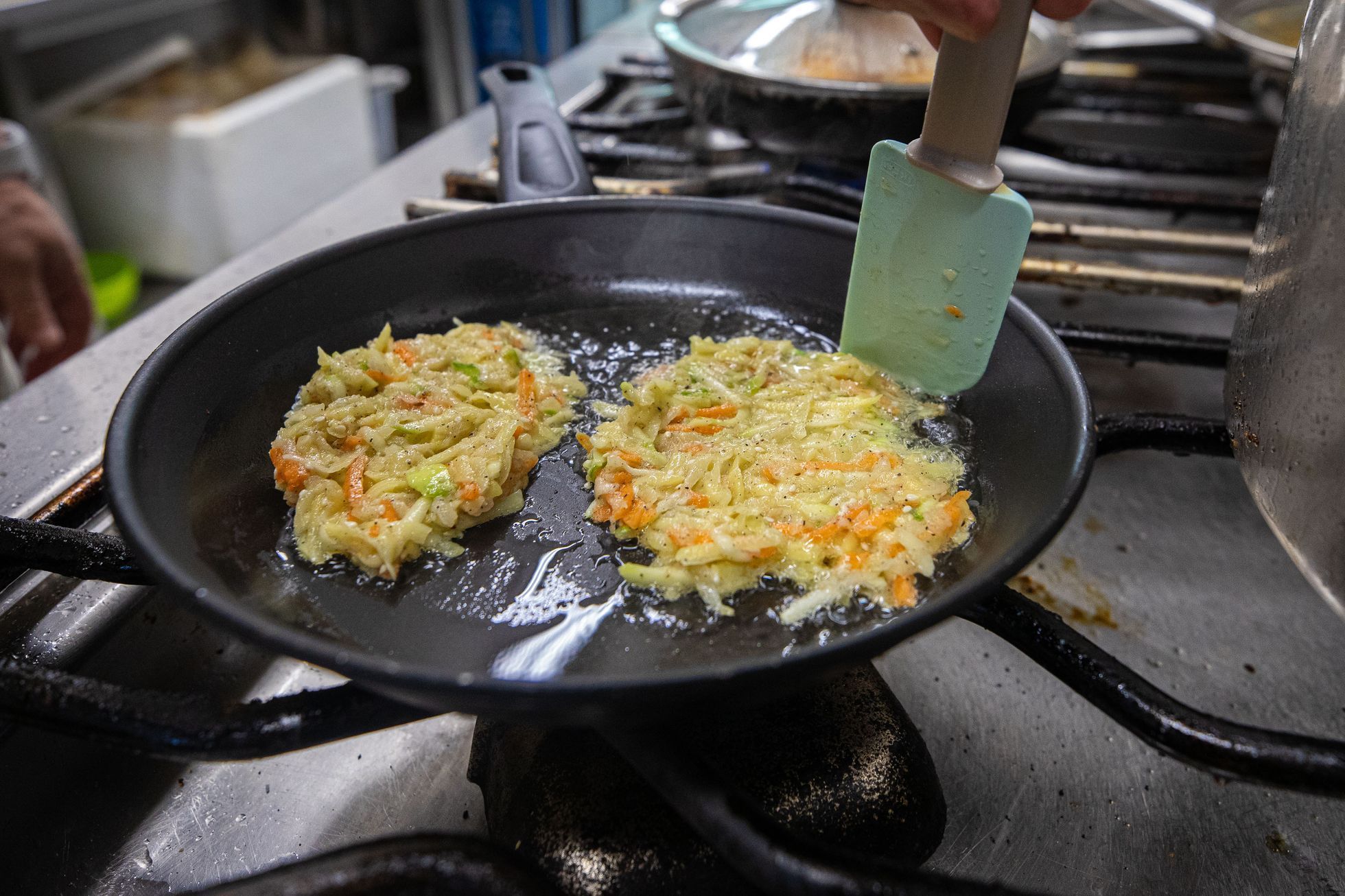 Restaurace Jerusalem v Praze a její majitel Avi Ben Perez připravující tradiční pokrm latkes (bramborák) na židovský svátek Chanuka