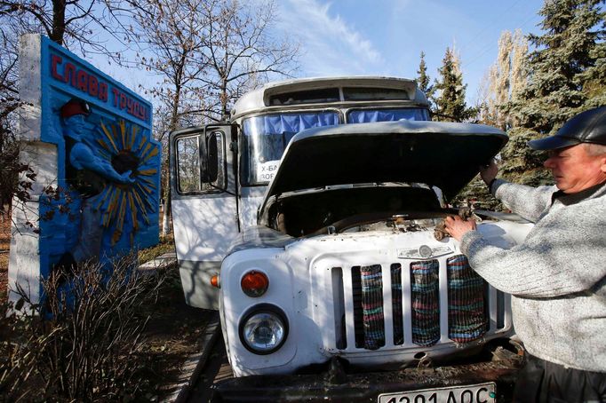 Řidič kontroluje motor autobusu, kterým převáží horníky do práce.