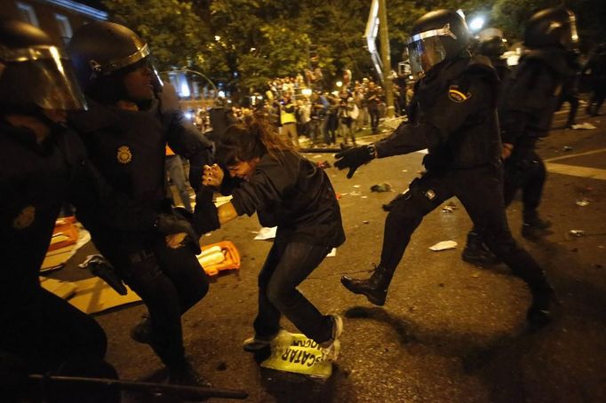 A protester yells as she is dragged away by riot police outside the Spanish parliament in Madrid, September 25, 2012. Protesters clashed with police in Spain's capital on Tuesday as the government prepares a new round of unpopular austerity measures for the 2013 budget that will be announced on Thursday. REUTERS/Susana Vera (SPAIN - Tags: CIVIL UNREST POLITICS) Published: Zář. 25, 2012, 8:25 odp.