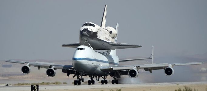 The space shuttle Endeavour, carried piggyback atop a Boeing 747 jumbo jet, lands at at Edwards Air Force Base in California, September 20, 2012, after a cross-country trip to Los Angeles to begin its final mission as a museum exhibit. Endeavour is scheduled to take off for its final ferry flight again on Friday, and the final airborne journey of the entire space shuttle fleet, headed for Los Angeles International Airport. REUTERS/Gene Blevins (UNITED STATES - Tags: TRANSPORT SCIENCE TECHNOLOGY) Published: Zář. 20, 2012, 10:41 odp.