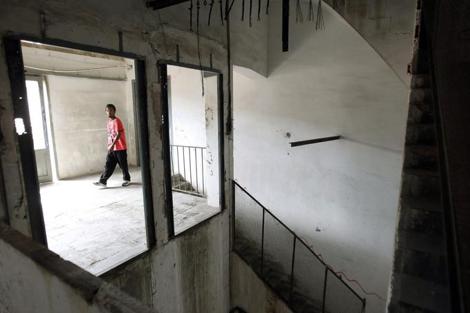 A squatter walks in a building of an industrial complex in the Poble Nou neighbourhood of Barcelona July 16, 2012. The squatters said that a police order to evict them from the complex was postponed by a judge on Monday. REUTERS/Albert Gea (SPAIN - Tags: SOCIETY REAL ESTATE BUSINESS POVERTY) Published: Čec. 16, 2012, 5:09 odp.