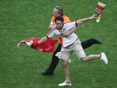 Pořadatel chytá tuniského fanouška, který vnikl na hřiště při zápase skupiny H Tunisko - Saudská Arábie.