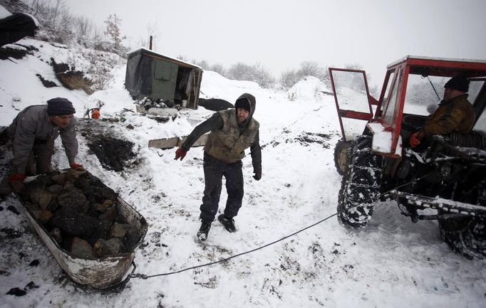 Illegal miners prepare to transport a bathtub filled with coal in the village of Stranjani, near Zenica, December 11, 2012. There are about 20 illegal mines in the area, where Bosnians dig for coal with their bare hands and use makeshift tools, such as bathtubs, to transport the coal. One bag of their coal is sold for 3 euros ($4 dollars), which is popular with the locals as it is cheaper than the coal sold at the city mine. REUTERS/Dado Ruvic (BOSNIA AND HERZEGOVINA - Tags: BUSINESS ENERGY SOCIETY CRIME LAW) BOSNIA AND HERZEGOVINA OUT. NO COMMERCIAL OR EDITORIAL SALES IN BOSNIA AND HERZEGOVINA Published: Pro. 11, 2012, 4:26 odp.