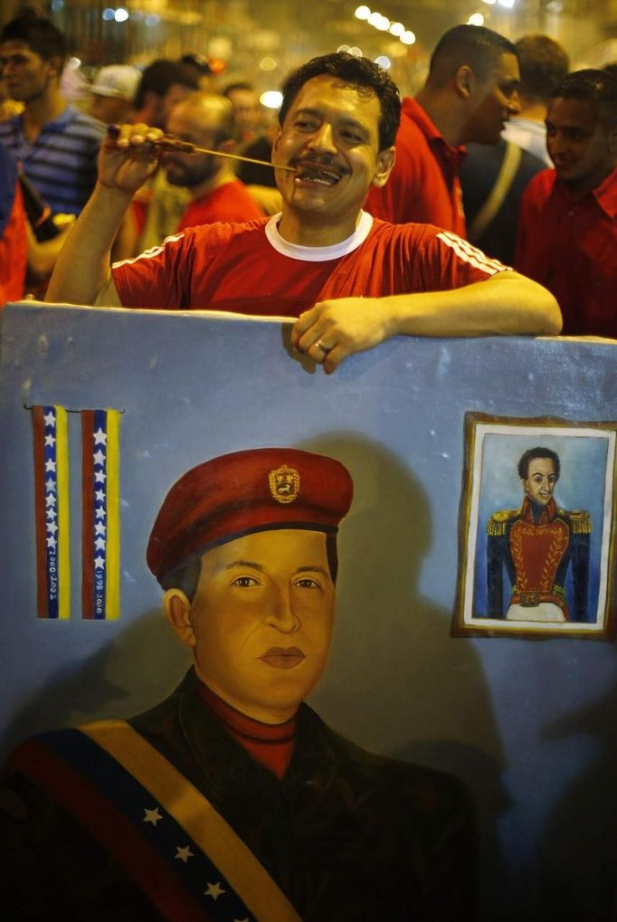 A supporter of Venezuelan President Hugo Chavez holds a portrait of him while celebrating his election victory in Caracas October 7, 2012. Chavez won re-election in Sunday's vote with 54 percent of the ballot to beat opposition challenger Henrique Capriles. REUTERS/Tomas Bravo (VENEZUELA - Tags: POLITICS ELECTIONS) Published: Říj. 8, 2012, 5:38 dop.