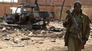 A Malian soldier walks past a destroyed vehicle, which according to Malian soldiers, belonged to Islamist rebels in the recently liberated town of Konna January 26, 2013. REUTERS/Eric Gaillard (MALI - Tags: CIVIL UNREST CONFLICT MILITARY) Published: Led. 26, 2013, 2:18 odp.