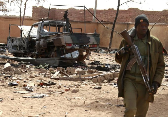 A Malian soldier walks past a destroyed vehicle, which according to Malian soldiers, belonged to Islamist rebels in the recently liberated town of Konna January 26, 2013. REUTERS/Eric Gaillard (MALI - Tags: CIVIL UNREST CONFLICT MILITARY) Published: Led. 26, 2013, 2:18 odp.