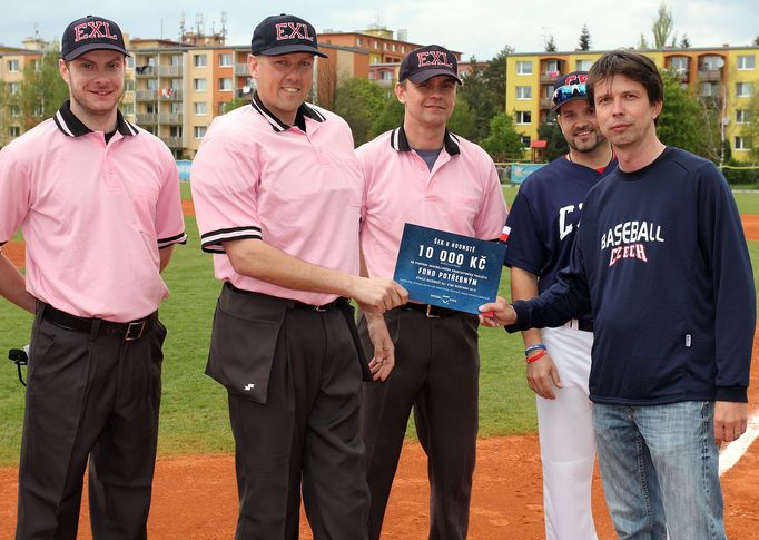 Hlavní rozhodčí All Star Game (v růžovém) předává šek na 10 tisíc korun zástupci projektu Baseball Czech Robertu Vávrovi. Pro fond potřebným se všichni rozhodčí All Star