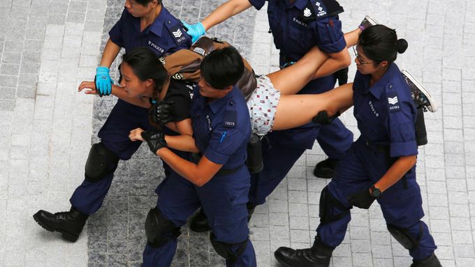 Demonstrantka, která protestovala u vládního komplexu v Hongkongu, je odváděna policií.