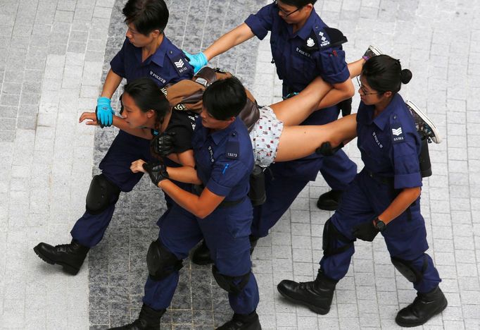 Demonstrantka, která protestovala u vládního komplexu v Hongkongu, je odváděna policií.