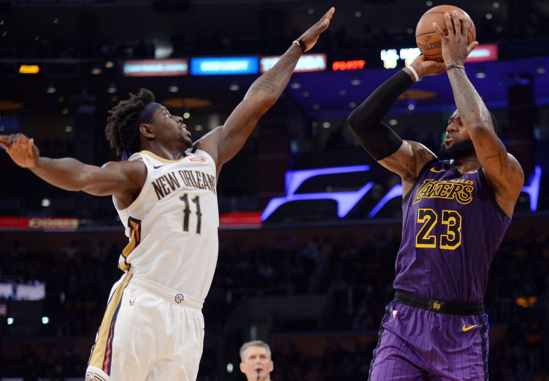 NBA 2018/19, LA Lakers - New Orleans: Hostující Jrue Holiday se snaží zablokovat střelu LeBrona Jamese.