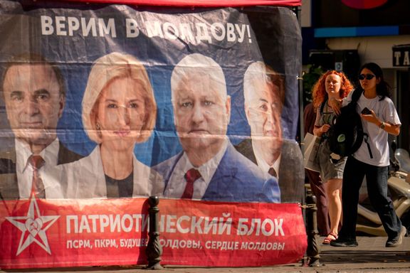 Žena před nedělními volbami prochází kolem stanu Vlasteneckého volebního bloku socialistů, komunistů, srdce a budoucnosti Moldavska. 23. září 2025, Kišiněv.