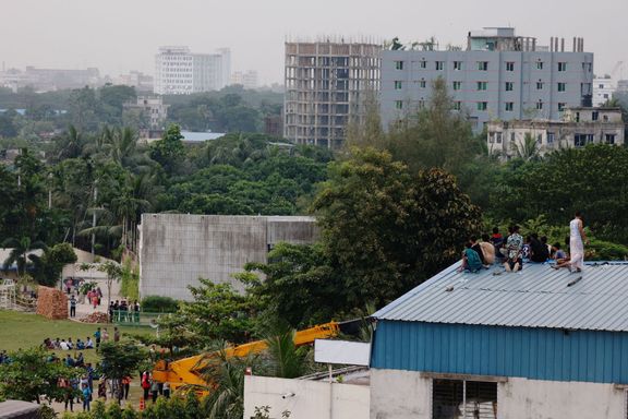 Přihlížející sledují záchrannou operaci ze střechy poté, co se 21. července 2025 cvičný letoun letectva zřítil do areálu Milestone College v Dháce, Bangladéš.
