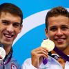Americký plavec Michael Phelps pózuje se stříbrnou medailí a vedle něj Jihoafričan Chad le Clos se zlatou za 200 metrů motýlek na OH 2012 v Londýně.