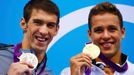 Americký plavec Michael Phelps pózuje se stříbrnou medailí a vedle něj Jihoafričan Chad le Clos se zlatou za 200 metrů motýlek na OH 2012 v Londýně.